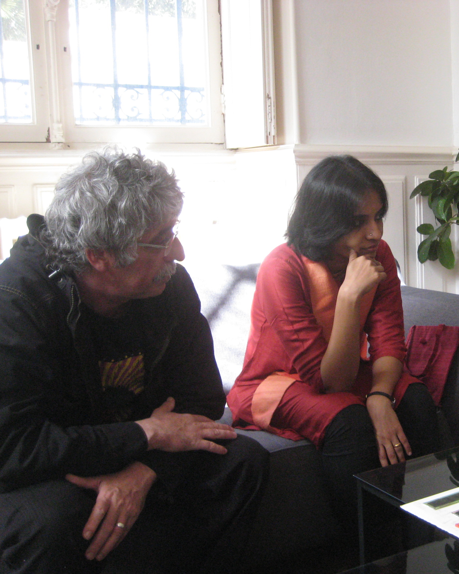 Anupama Raju and Pascal Bernard sitting on a couch.